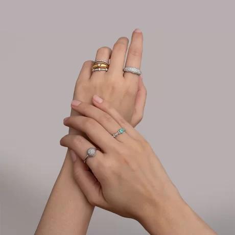 mãos com mix de anéis com diamantes e turmalina paraíba